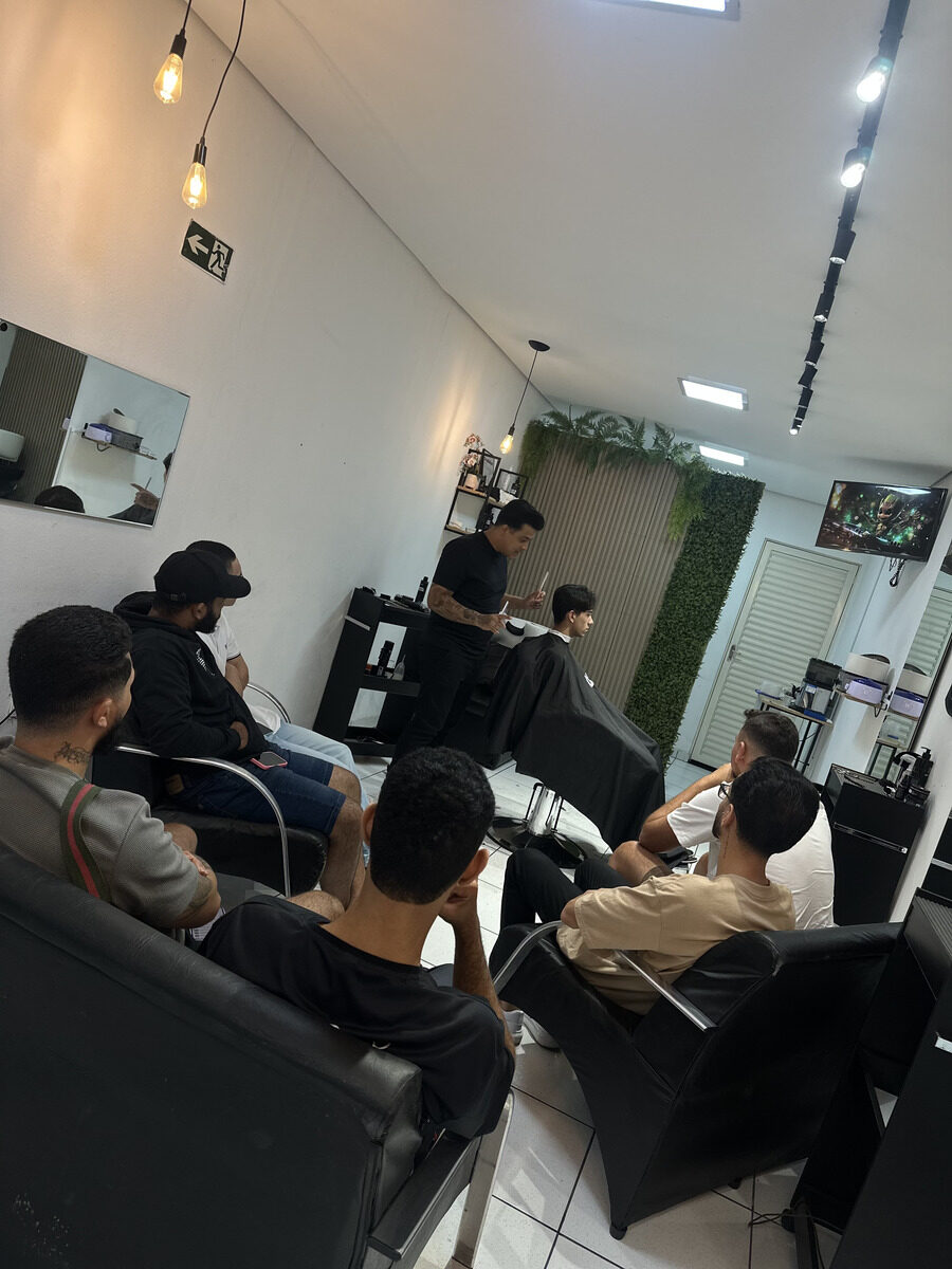 Turma acompanhando aula prática de barbearia